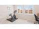 Bright exercise room featuring large windows with views, a stationary bike, desk, and a comfortable office chair at 1526 Golden Sill Dr, Castle Pines, CO 80108