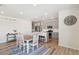 Open-concept kitchen and dining area featuring gray cabinets, wood floors, and modern lighting fixtures at 1526 Golden Sill Dr, Castle Pines, CO 80108