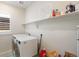 Functional laundry room with washer, dryer, shelving, and a window for natural light at 1526 Golden Sill Dr, Castle Pines, CO 80108