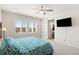 Primary bedroom featuring plantation shutters, ceiling fan, and a sliding door to the bathroom at 1526 Golden Sill Dr, Castle Pines, CO 80108