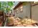 Exterior view of backyard with a wood patio area, landscaping and pathway lighting, providing a private retreat at 7444 E 9Th Ave, Denver, CO 80230