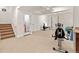 Finished basement with exercise equipment, carpeted stairs and a view of the entry door at 7444 E 9Th Ave, Denver, CO 80230