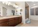 Bright bathroom featuring a double vanity, large mirror, and separate shower and tub at 7444 E 9Th Ave, Denver, CO 80230
