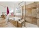 A bathroom featuring a tub and a separate shower with glass door at 7444 E 9Th Ave, Denver, CO 80230