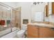 A bathroom with a shower, a sink, and a mirror at 7444 E 9Th Ave, Denver, CO 80230