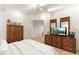 Bright bedroom with wooden furniture, a white bed, and a TV at 7444 E 9Th Ave, Denver, CO 80230