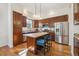 Well-lit kitchen with stainless steel appliances, wood cabinets, a granite countertop island, and a hardwood floor at 7444 E 9Th Ave, Denver, CO 80230