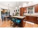 Kitchen area with center island and breakfast bar seating, wood cabinets, stainless appliances and an adjacent dining area at 7444 E 9Th Ave, Denver, CO 80230
