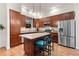 Well-equipped kitchen featuring stainless steel appliances, a central island with seating, and wooden cabinets at 7444 E 9Th Ave, Denver, CO 80230