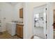 A laundry room with a washer and dryer set, utility sink, and adjacent office space at 7444 E 9Th Ave, Denver, CO 80230