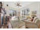 Inviting living room featuring hardwood floors, fireplace, a ceiling fan, and large windows for plenty of natural light at 7444 E 9Th Ave, Denver, CO 80230