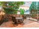 Outdoor patio with a dark wooden fence, a round table, and four chairs under the shade of a tree at 7444 E 9Th Ave, Denver, CO 80230