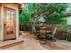 Outdoor patio with a round table and four chairs, a wooden fence, and a glass door leading inside at 7444 E 9Th Ave, Denver, CO 80230