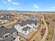 An aerial view of a modern neighborhood featuring sidewalks, lush landscaping, and mountain views at 1180 Ascent Trail Cir, Erie, CO 80516