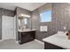 Elegant bathroom featuring dual sinks, modern fixtures, decorative wallpaper, and a tiled floor at 1180 Ascent Trail Cir, Erie, CO 80516