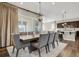 Formal dining room with a large table, modern chandelier, and access to a patio at 1180 Ascent Trail Cir, Erie, CO 80516