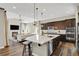 Open-concept kitchen featuring a large island with bar seating, dark cabinets, and modern appliances at 1180 Ascent Trail Cir, Erie, CO 80516