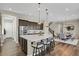 Open kitchen with stainless steel appliances, large island, pendant lighting, and seamless flow into the dining area at 1180 Ascent Trail Cir, Erie, CO 80516