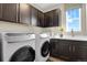 Well-organized laundry room with modern appliances, ample cabinet space, and a sink with stylish faucet at 1180 Ascent Trail Cir, Erie, CO 80516