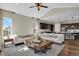 Open living room featuring dark cabinets, a large kitchen island, a beamed ceiling and many windows for natural light at 1180 Ascent Trail Cir, Erie, CO 80516