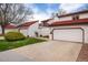 Townhome with red tile roof and white stucco exterior with a well-maintained lawn at 1321 Madero St, Broomfield, CO 80020
