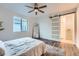 A bright bedroom features a barn door, a full length mirror, and ceiling fan at 26902 E Ellsworth Ave, Aurora, CO 80018
