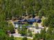 Panoramic aerial view of a stunning luxury home nestled in a lush green forest at 534 W Meadow Rd, Evergreen, CO 80439
