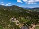 Breathtaking aerial view of a luxury home nestled in the mountains surrounded by lush forest at 534 W Meadow Rd, Evergreen, CO 80439