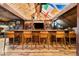 Finished basement with a custom bar, seating, and a unique wood-paneled ceiling at 534 W Meadow Rd, Evergreen, CO 80439