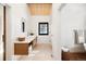 Bright bathroom featuring a double vanity, modern fixtures, and a stylish wood accent ceiling at 534 W Meadow Rd, Evergreen, CO 80439