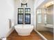 Luxurious bathroom featuring a soaking tub, glass enclosed shower, wood floors and stylish fixtures at 534 W Meadow Rd, Evergreen, CO 80439