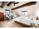 Cozy bedroom features a vaulted ceiling with wooden beams, hardwood floors, and a comfortable bed at 534 W Meadow Rd, Evergreen, CO 80439