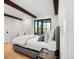 Bright bedroom with wooden beams, hardwood floors, large windows, and a comfortable bed at 534 W Meadow Rd, Evergreen, CO 80439