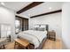Serene bedroom featuring wooden beams, hardwood floors, large windows, and stylish modern furniture at 534 W Meadow Rd, Evergreen, CO 80439