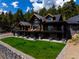 Two story home with a stone foundation, wood siding, and outdoor living area with seating and lush lawn at 534 W Meadow Rd, Evergreen, CO 80439