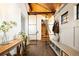 Inviting foyer featuring wood beams, a built-in bench, and a striking wooden staircase at 534 W Meadow Rd, Evergreen, CO 80439