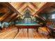 Attic game room with a pool table, wood beams, and rustic decor at 534 W Meadow Rd, Evergreen, CO 80439