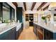 Kitchen view with stainless steel appliances, island, farmhouse sink and wooden beams at 534 W Meadow Rd, Evergreen, CO 80439