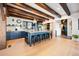 A spacious kitchen shows a long island with seating, beams and light wood floors at 534 W Meadow Rd, Evergreen, CO 80439