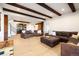 Spacious living room with exposed wood beams, wood floors, leather seating, and a stylish bar area at 534 W Meadow Rd, Evergreen, CO 80439