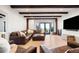 Open living room with exposed beams, wood flooring, and an abundance of natural light at 534 W Meadow Rd, Evergreen, CO 80439