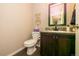 Well-lit half bathroom with a vanity, decorative mirror, and modern fixtures at 605 Wild Honey Dr, Berthoud, CO 80513