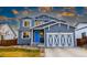 Attractive two-story home with a vibrant blue front door, complemented by a decorative garage door at 605 Wild Honey Dr, Berthoud, CO 80513