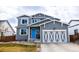 Two-story home with a blue front door and a well-maintained lawn creating a welcoming curb appeal at 605 Wild Honey Dr, Berthoud, CO 80513