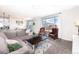 Inviting living room with a sectional sofa, leather chairs, and a window offering neighborhood views at 605 Wild Honey Dr, Berthoud, CO 80513