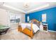 Bright main bedroom features a four-poster bed, blue accent wall and large window for lots of natural light at 605 Wild Honey Dr, Berthoud, CO 80513