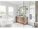 Bathroom with double vanity, freestanding tub, glass enclosed shower, and large windows at 1665 S Fillmore St, Denver, CO 80210