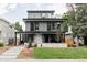 Stunning three-story home with a stone facade, modern wood siding, and rooftop terrace with glass railing at 1665 S Fillmore St, Denver, CO 80210