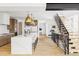 Open-concept kitchen with oversized island, marble countertop, statement lighting, and stainless steel appliances at 1665 S Fillmore St, Denver, CO 80210