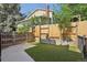 Backyard featuring artificial grass, wooden fencing, and a view of the home's exterior at 215 Sunland St, Louisville, CO 80027
